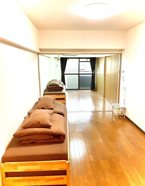 three beds in a room with a wooden floor at Pleasant 203 - Vacation STAY 37857v in Kitakyushu