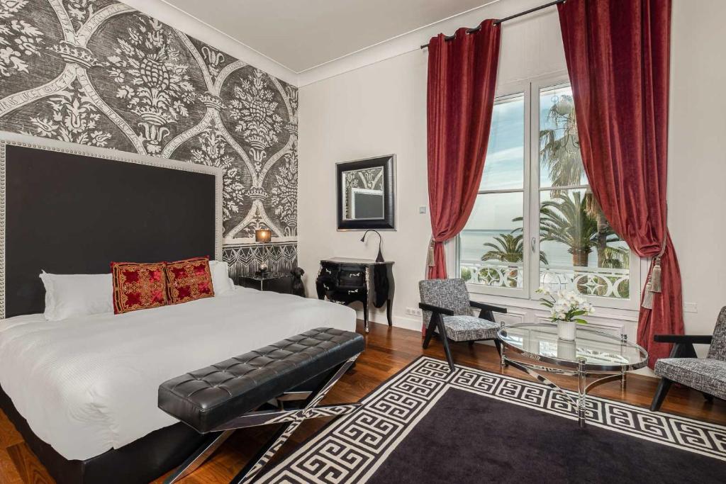 a bedroom with a bed and a desk and a window at La Villa Mauresque in Saint-Raphaël