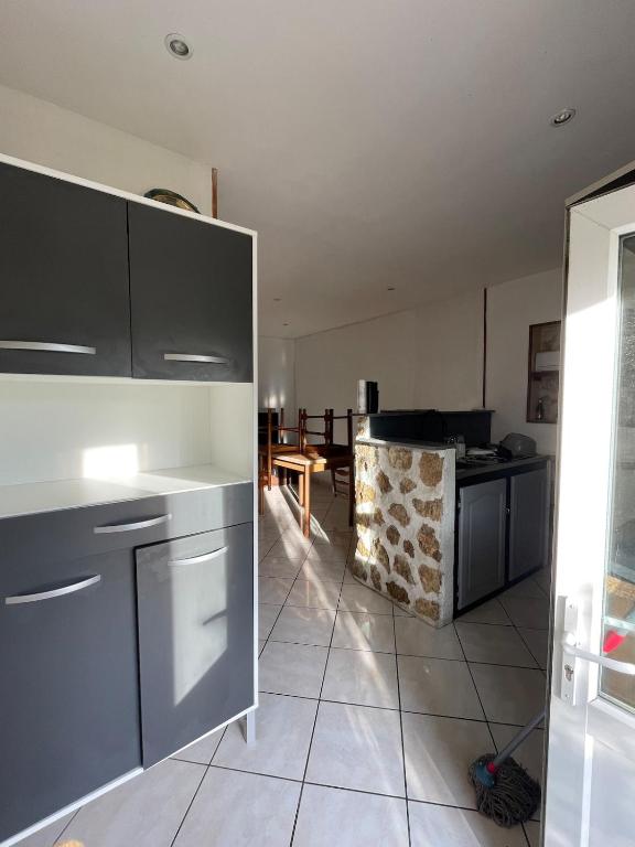 une cuisine avec des appareils en acier inoxydable et une table dans l'établissement Country apartment, à La Croix-sur-Ourcq