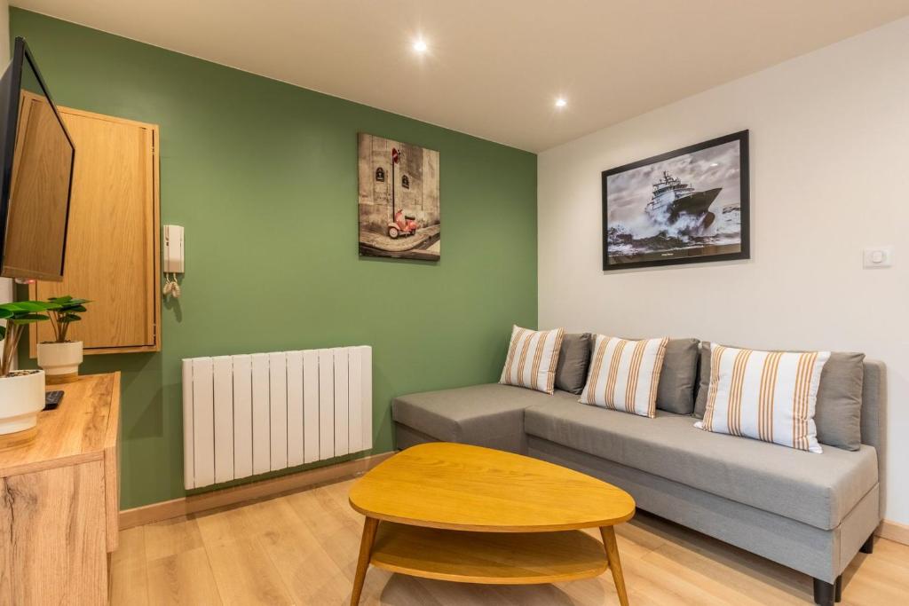 a living room with a couch and a table at Duplex une chambre calme, proche commodités in Lille