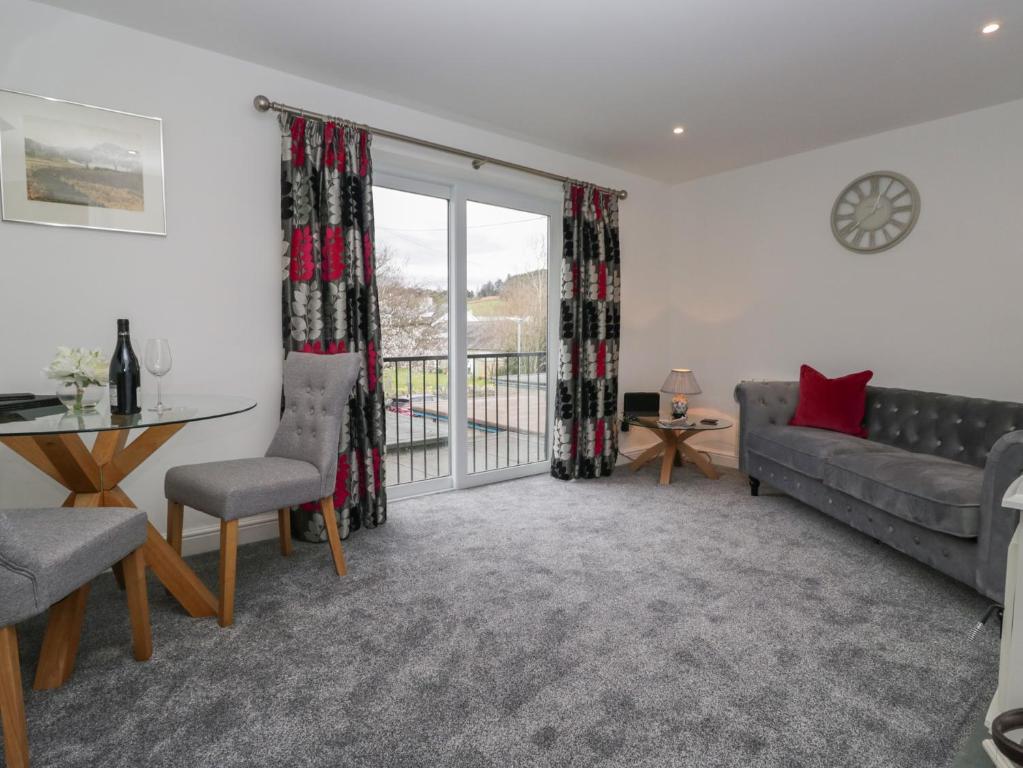 a living room with a couch and a table and chairs at Yewdale View Apartment in Coniston