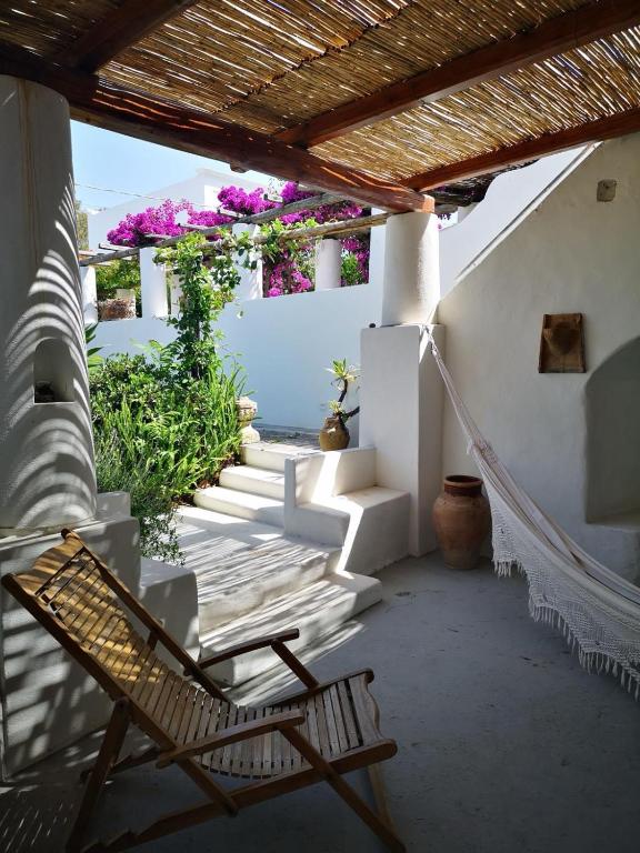 a chair on a porch with stairs and flowers at La Porta Rossa in Stromboli