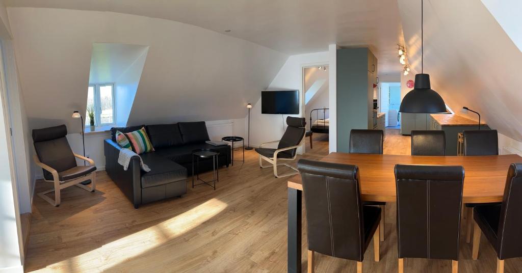 a living room and dining room with a table and chairs at Søndervang, lejlighed 1sal in Svinninge