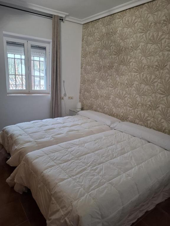 A bed or beds in a room at Casa La Sinagoga de Trujillo