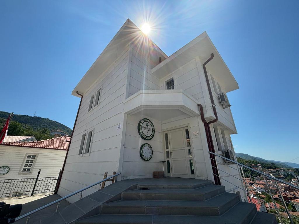 a white building with a clock on it at İnebolu Eskonak Otel in Inebolu