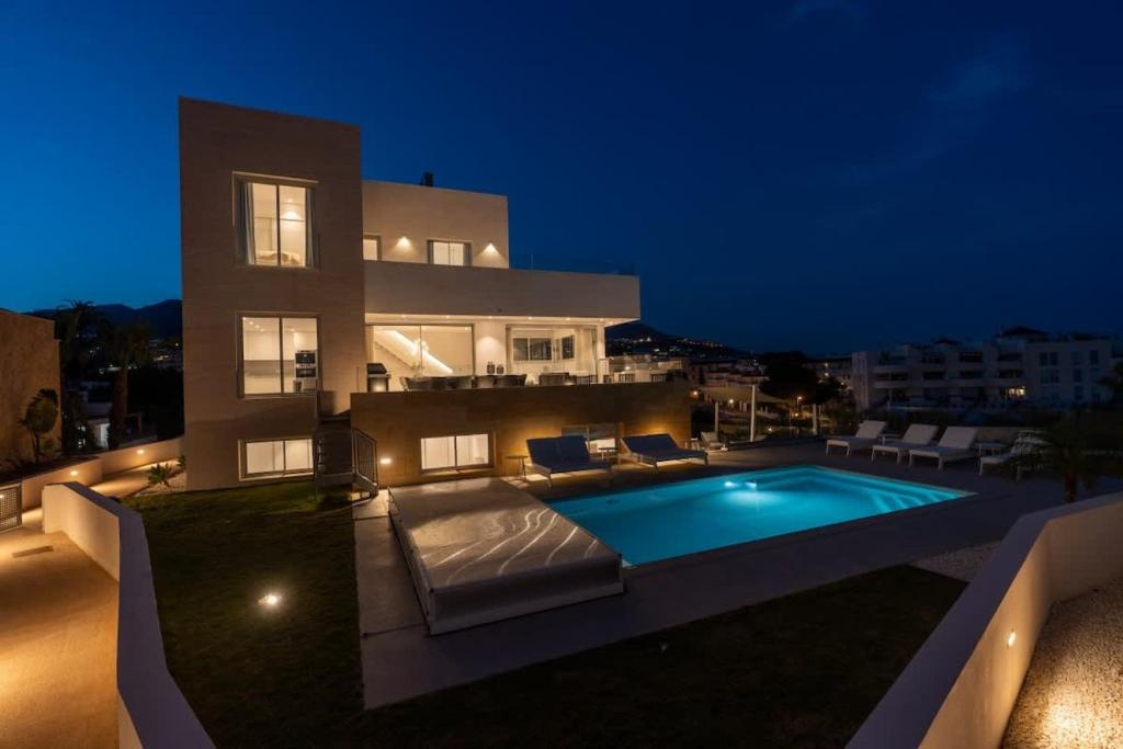 a house with a swimming pool at night at Villa Palm Beach - Incredible villa with 5 rooms, amazing sea view and private pool in Fuengirola