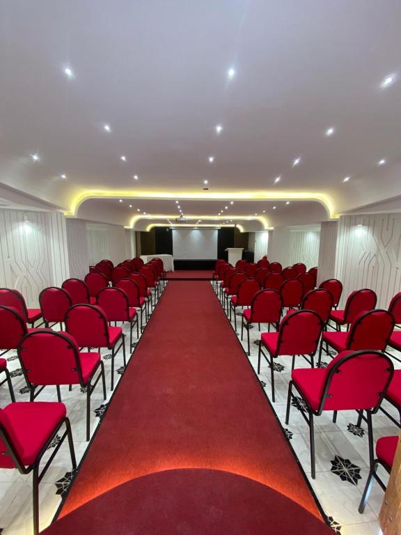 a conference room with red chairs and a red carpet at Hôtel Djerba Authentique - Au centre de Midoun in Midoun