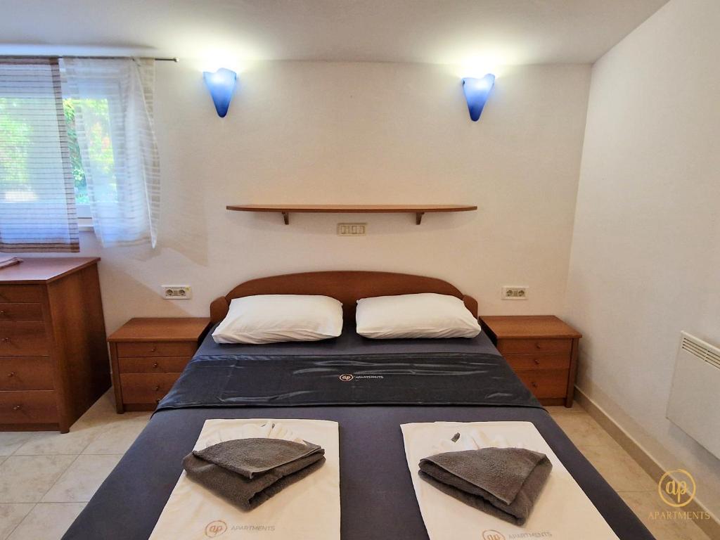 a bedroom with a bed with two pillows on it at Riverside Apartments - pet friendly in Sečovlje
