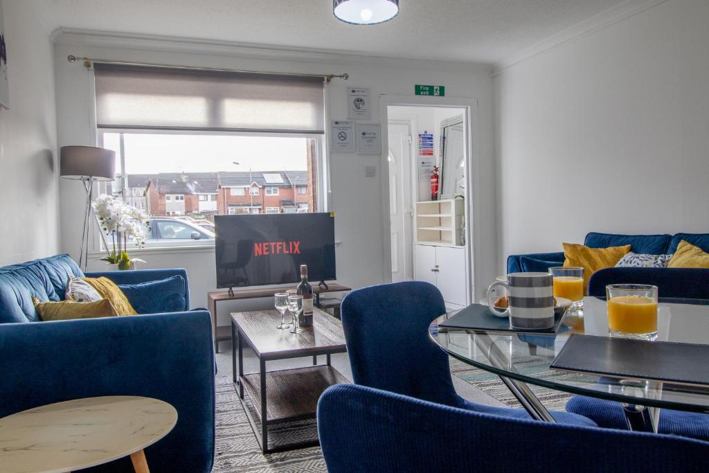 a living room with blue chairs and a table at Spacious 2-Bed City Home Free Parking & Stadiums in Glasgow