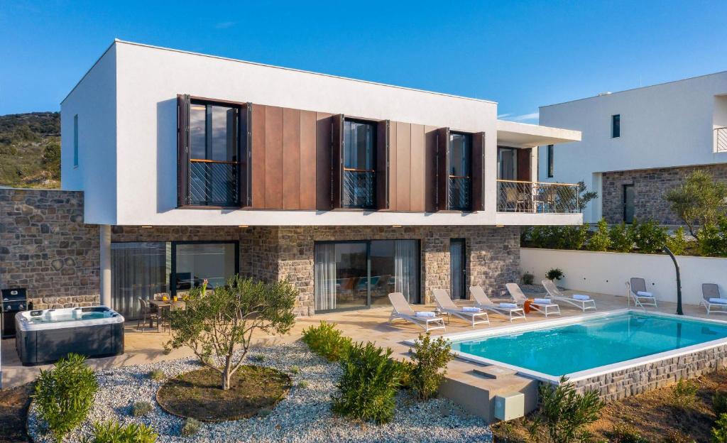 une maison avec une piscine devant dans l'établissement Villa Mattina, à Dolac