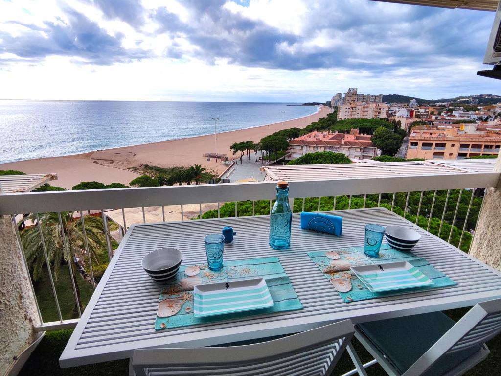 a table on a balcony with a view of the beach at Apartamentos con vistas al mar in Platja  d'Aro