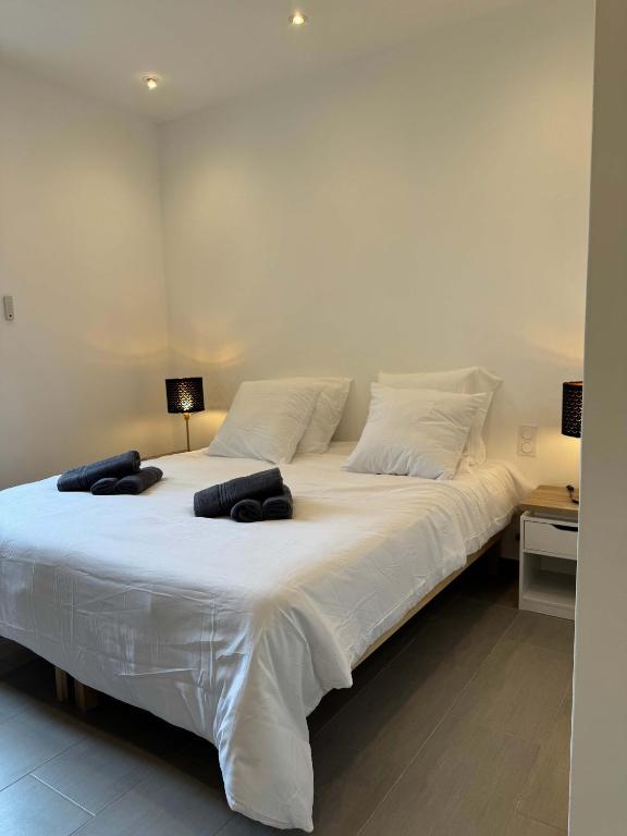 un grand lit blanc avec deux oreillers dessus dans l'établissement RARE - New apartment in the heart of Cannes, à Cannes