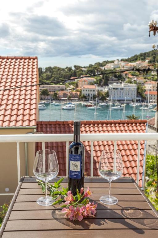 a bottle of wine sitting on a table with two glasses at Apartman Ana in Hvar