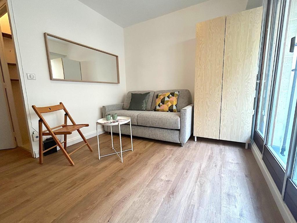 un salon avec un canapé et une table dans l'établissement L'appartement Larminat, à Paris