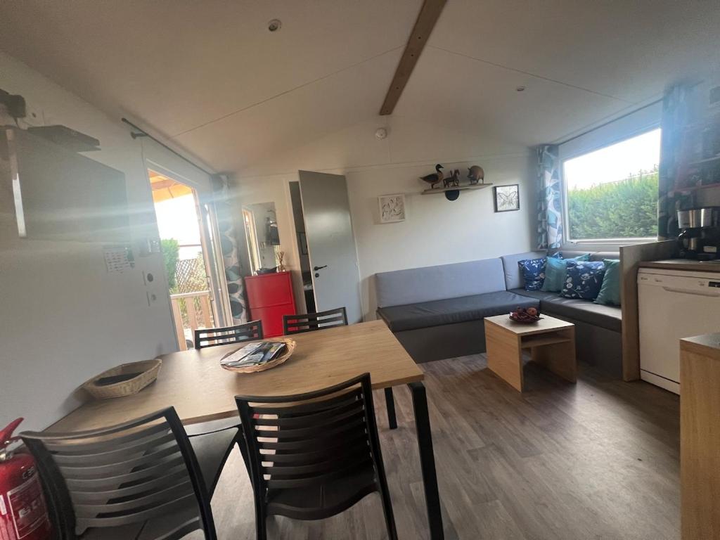 un soggiorno con tavolo, sedie e divano di 538 mobile home grand confort a La Teste-de-Buch