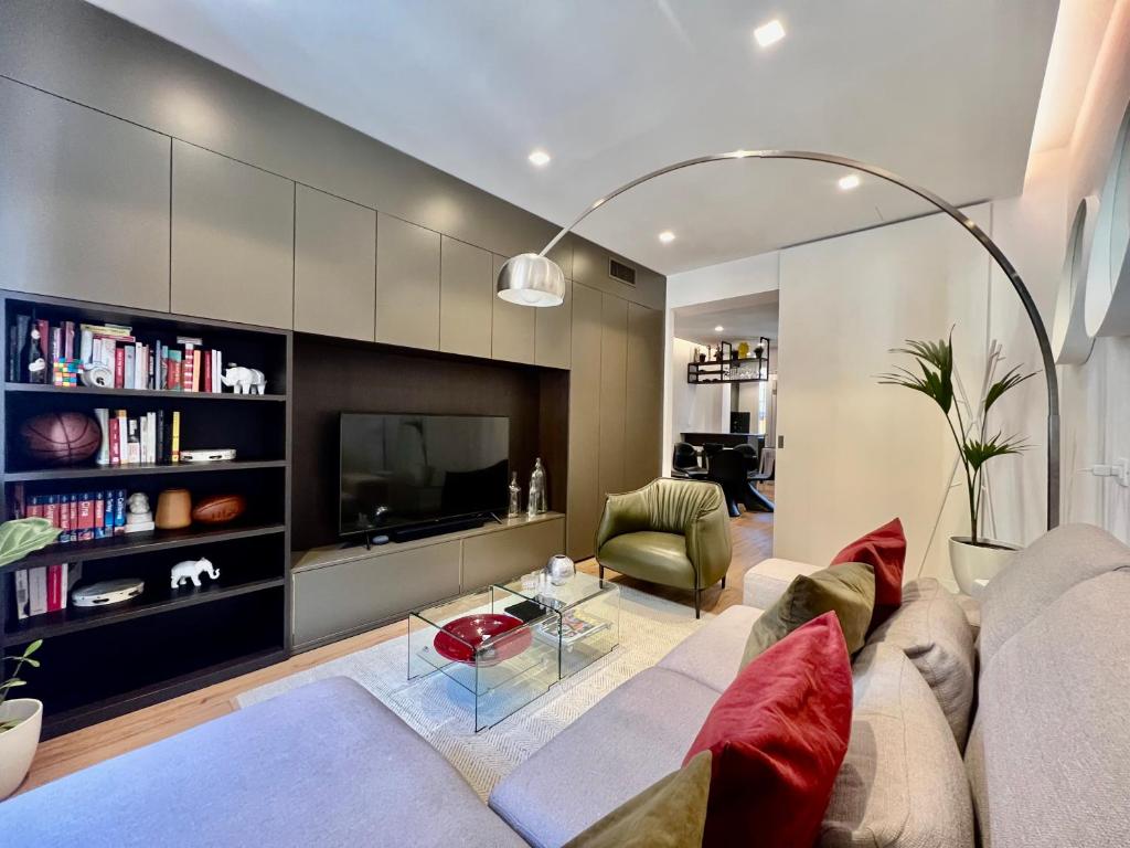 Una sala de estar con un sofá y un televisor. en BIG Luxury - California M4, en Milán