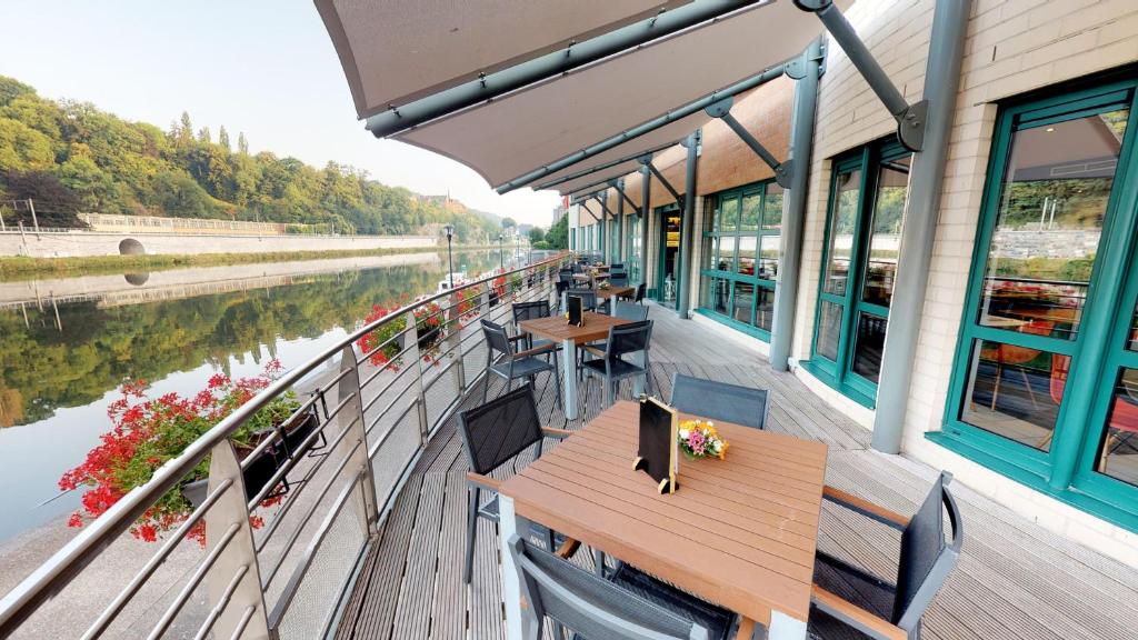 a restaurant with tables and chairs on the deck of a boat at ibis Dinant Centre in Dinant