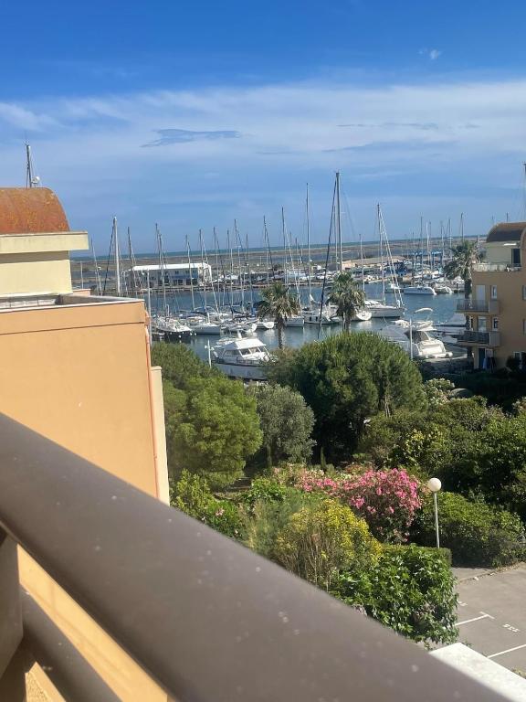 un balcon avec vue sur une marina avec des bateaux dans l'établissement Évasion Méditerranéenne, à Gruissan