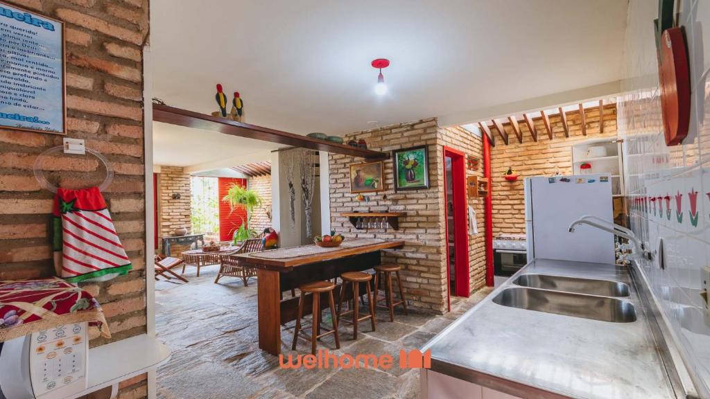 a kitchen with a table and a refrigerator in a room at Casa charmosa a beira-mar em Paripueira - AL in Paripueira