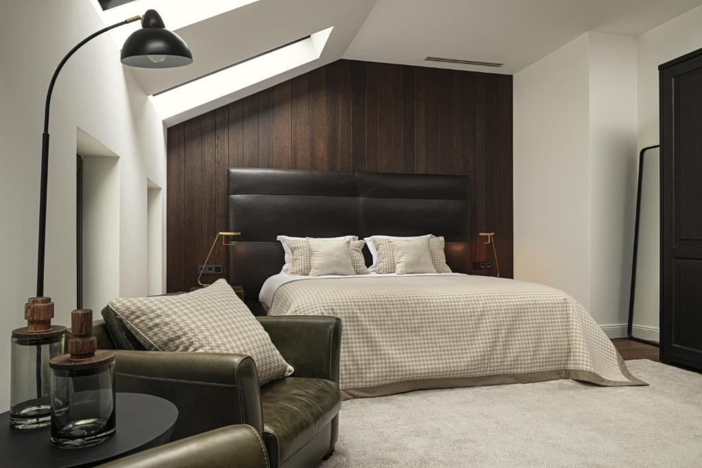 a bedroom with a bed and a leather couch at Maison 45 - Luxury Boutique Hotel in Budapest