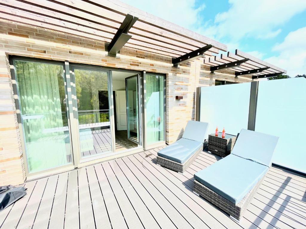 a deck with two chairs and awning at Villa Wattfuss in St. Peter-Ording