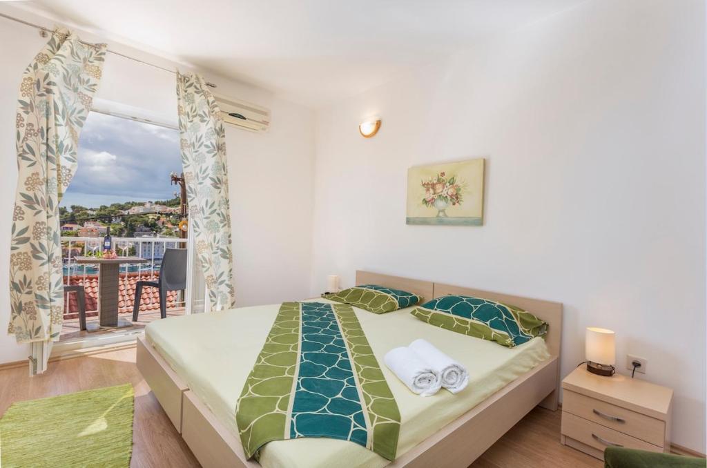 a bedroom with a bed and a large window at Apartman Ana in Hvar