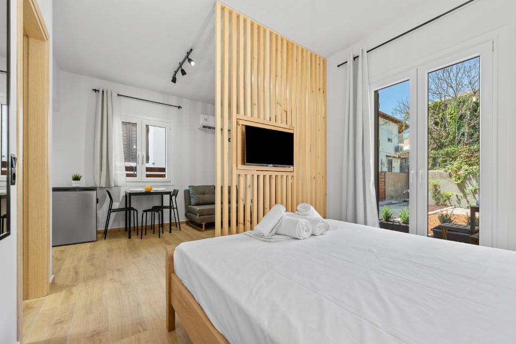 ein Schlafzimmer mit einem weißen Bett und ein Esszimmer in der Unterkunft Carina Studios Lefkada 2 in Lefkada Town