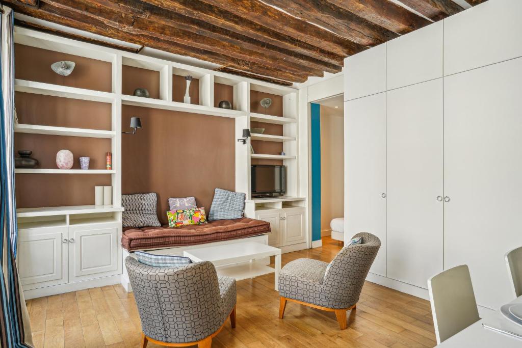 un salon avec un canapé et des chaises dans l'établissement Superb Apartment 1BR 2P - Cœur du Marais, à Paris