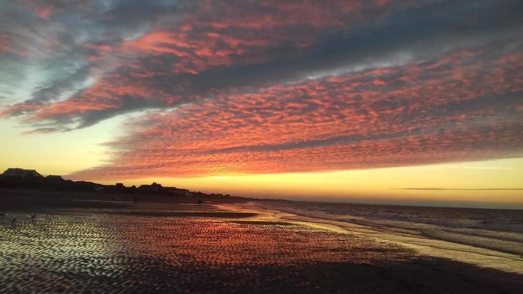 a sunset on the beach with a cloudy sky at Appartement charmant avec vue sur la mer à Cabourg - 30 m² in Cabourg