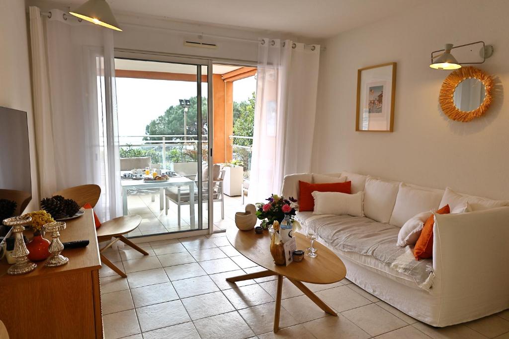 a living room with a white couch and a table at Les Sanguinaires N'7 - T2 Vue Mer, Piscine & Plage in Ajaccio