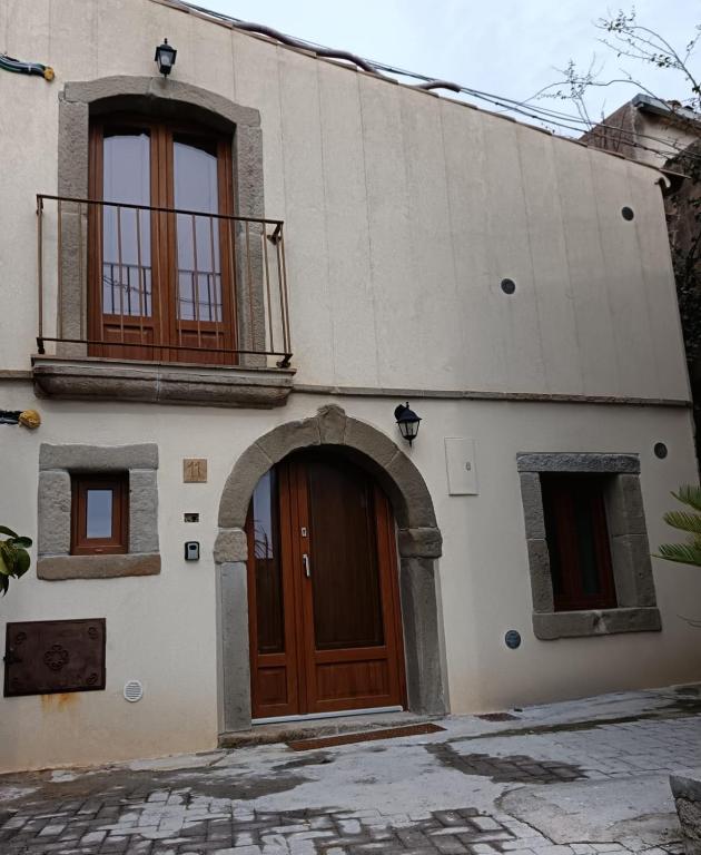 a building with a wooden door and a balcony at Da Giorgia in Forza dʼAgro