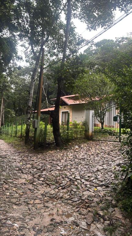 a house with a tree in front of a driveway at Chalé cantinho do céu in Guaramiranga