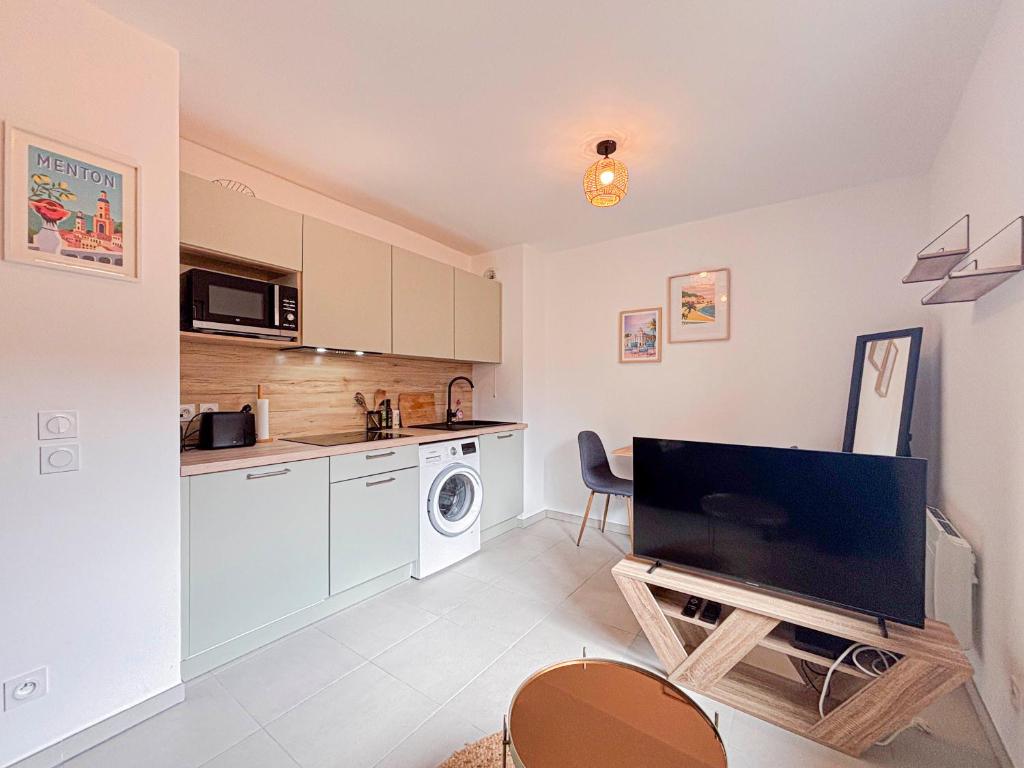 un salon avec une télévision et une cuisine dans l'établissement Confort & Élégance - Wifi, 2 pers, à Nice