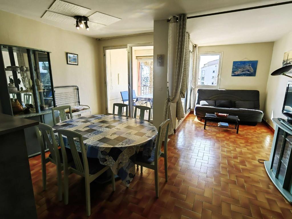 un salon avec une table et un canapé dans l'établissement Spacieux T3 avec piscine et parking près du port - FR-1-607-10, au Cap d'Agde