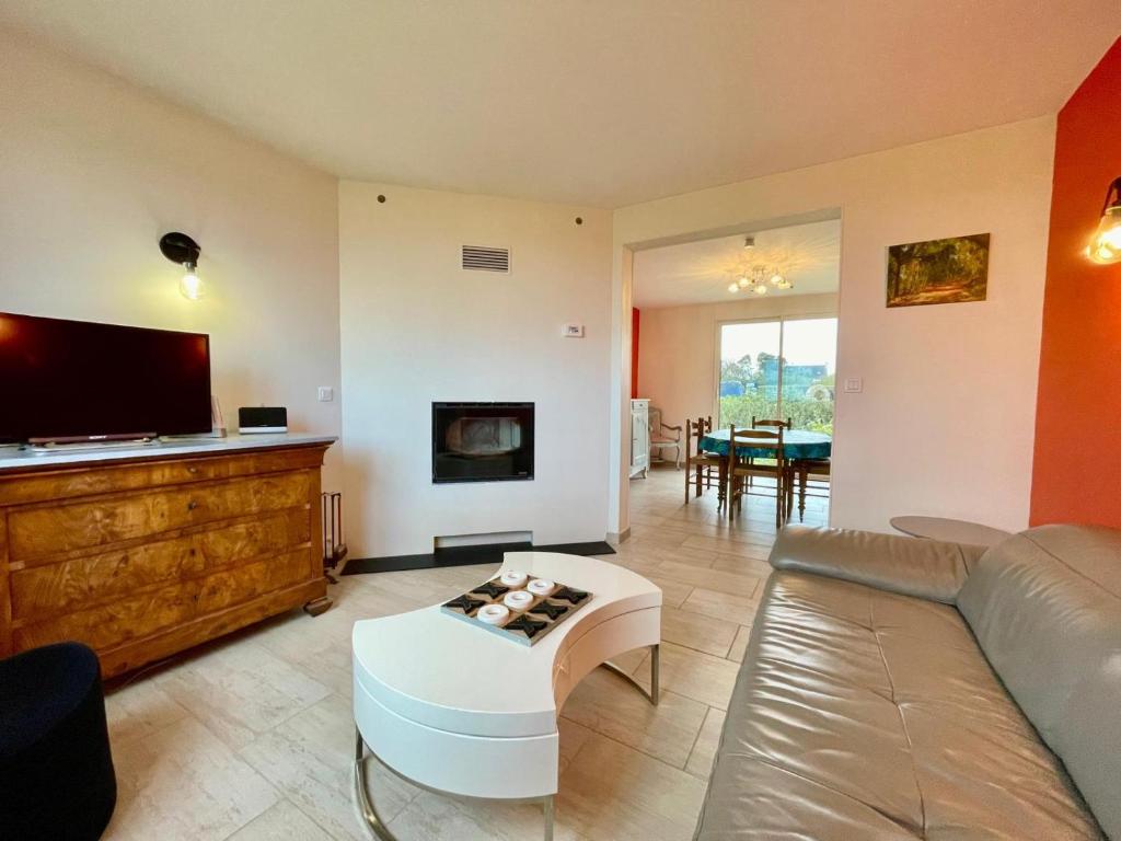 un salon avec un canapé et une télévision dans l'établissement Maison de famille Henvic, à Henvic