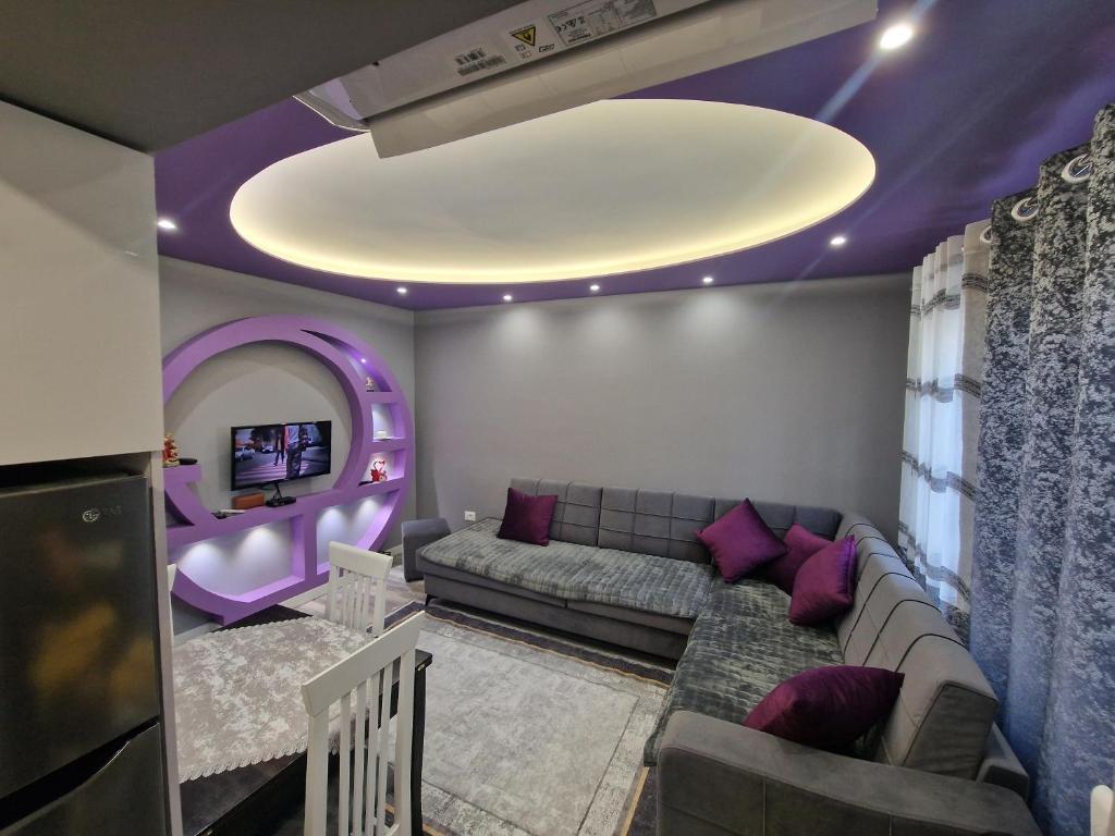 a living room with a couch and a tv at Emei Apartament in Pogradec