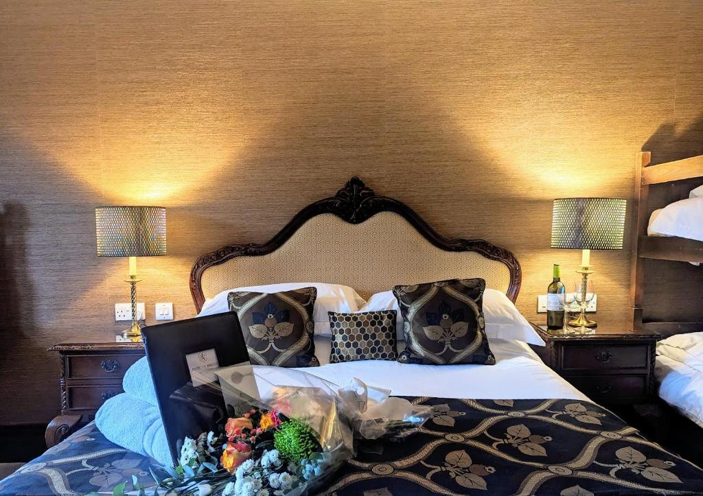 a hotel room with a bed with a flower arrangement on it at Parc-Le-Breos House in Penclawdd