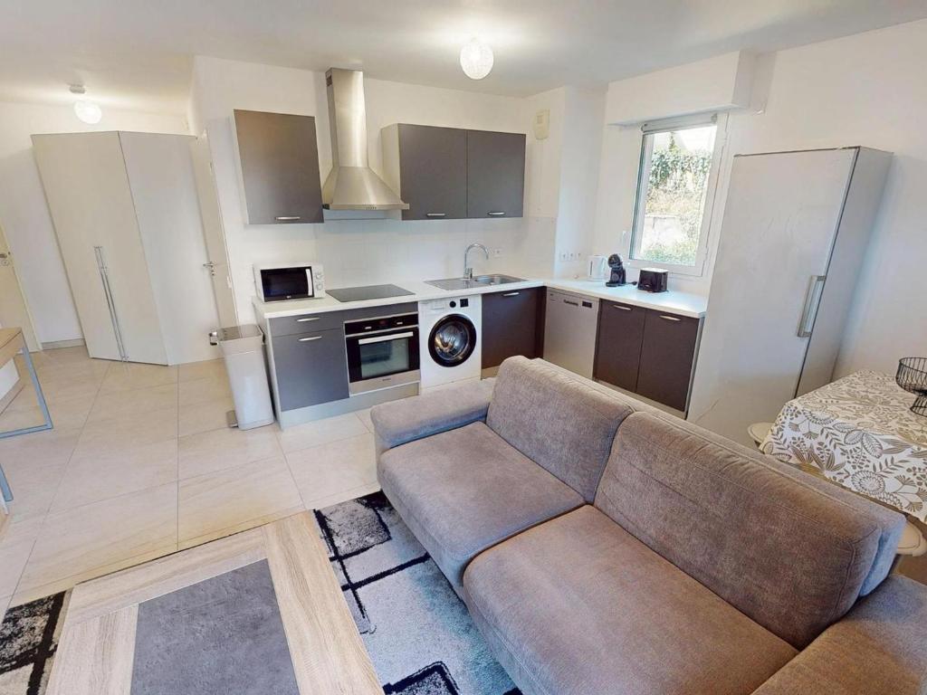 un salon avec un canapé et une cuisine dans l'établissement T2 climatisé avec balcon, garage et wifi - proche mer et gare - FR-1-196-371, à Roquebrune-Cap-Martin