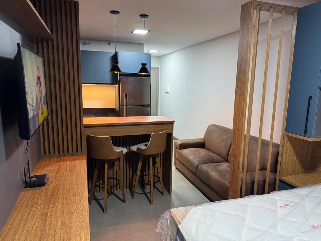 a kitchen with a bar and a couch in a room at Loft in Xangri-lá