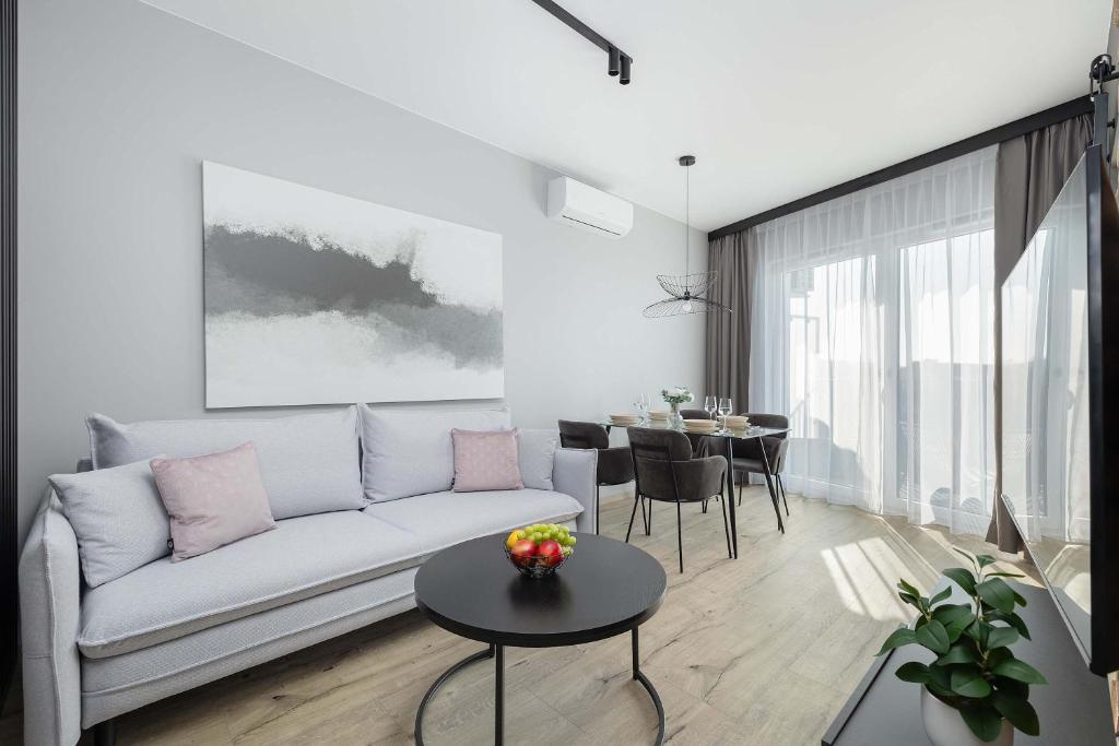 a living room with a couch and a table at Baltic Waves Resort w Międzyzdrojach Blisko Plaży & Parking by Noclegi Renters in Międzyzdroje