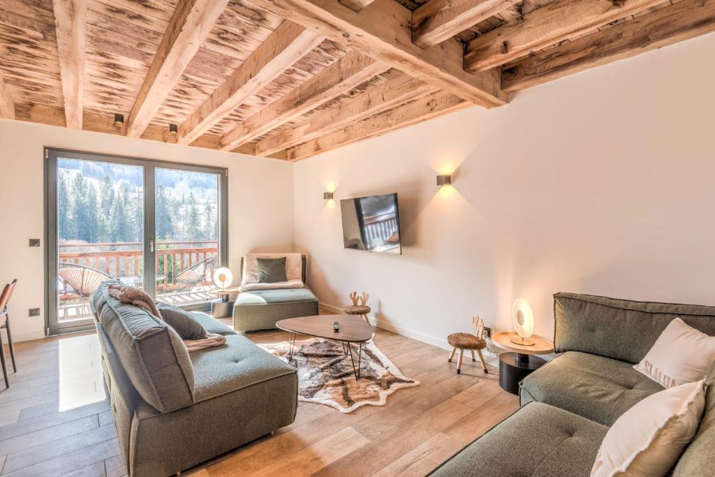 un salon avec un canapé et deux chaises dans l'établissement Chalet Shana - Welkeys, à Praz-sur-Arly