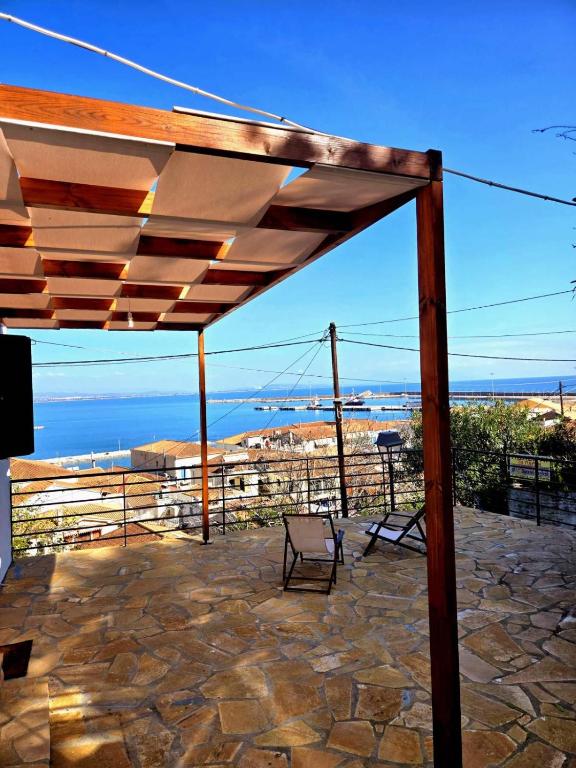 a wooden pergola with a chair on a patio at Katakolo 2 Bedroom Apartment by MPS in Katakolo