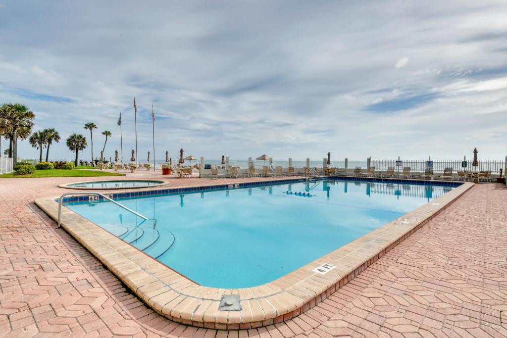 a large swimming pool with blue water at Daytona Beach Condo with Ocean-View Balcony! in Daytona Beach