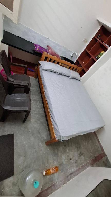 a bedroom with a bed and a chair in a room at Ashwin Home Stay 2 in Tiruvannāmalai