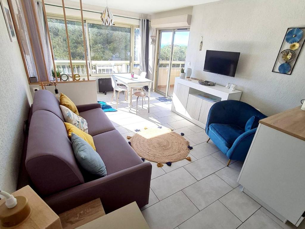 un salon avec un canapé violet et une télévision dans l'établissement T2 avec Piscine et Tennis - Parking - 250 m de la plage - FR-1-316-288, à Six-Fours-les-Plages