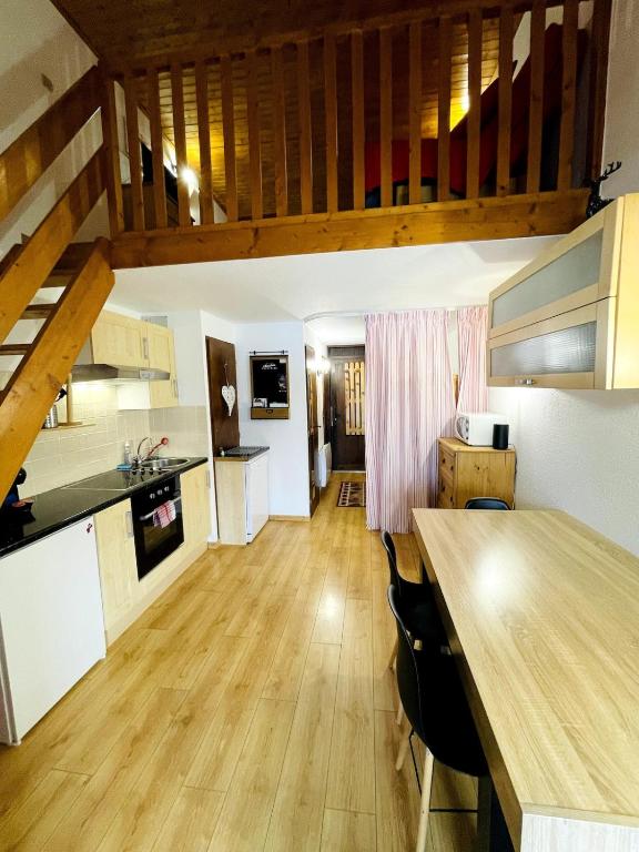 Il comprend une cuisine dotée de parquet et d'une table en bois. dans l'établissement Le Gibannaz, aux Gets