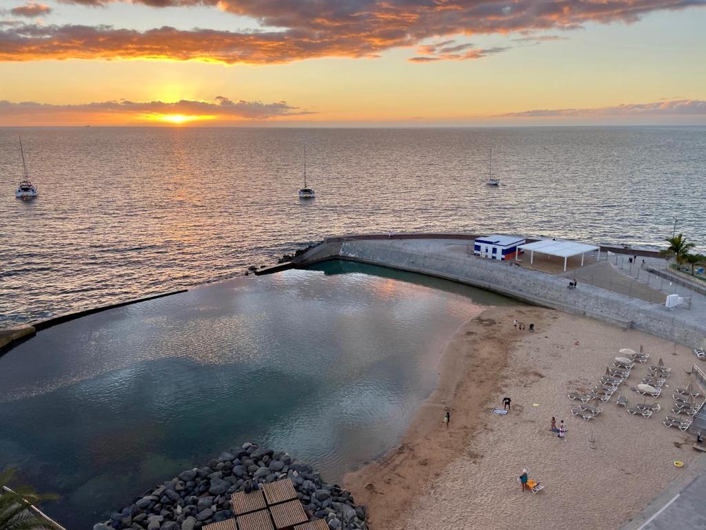 an overhead view of a swimming pool next to a beach at Beach Apartment Arguineguin in Arguineguín