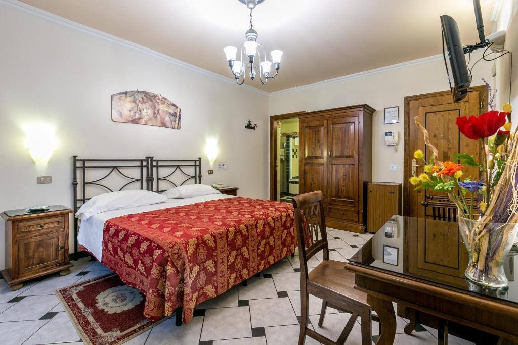 a bedroom with a bed and a table and a desk at Hotel Collodi Firenze in Florence