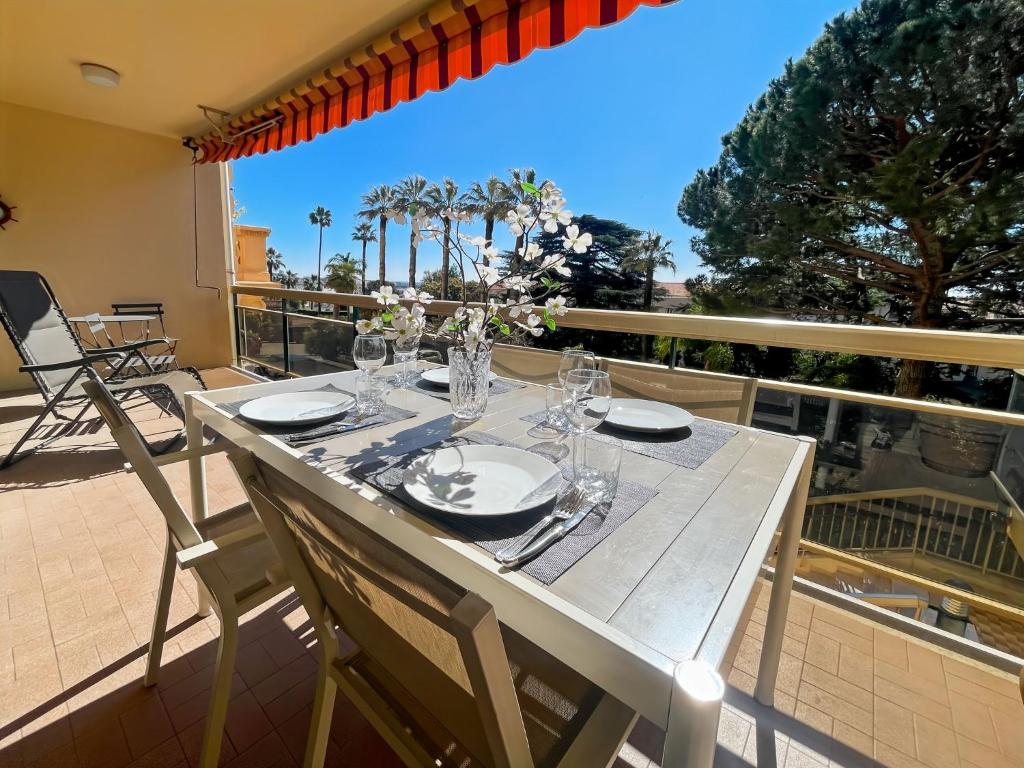 une table blanche avec des verres et des assiettes sur un balcon dans l'établissement Deluxe 2 bedroom apartment with parking, à Cannes