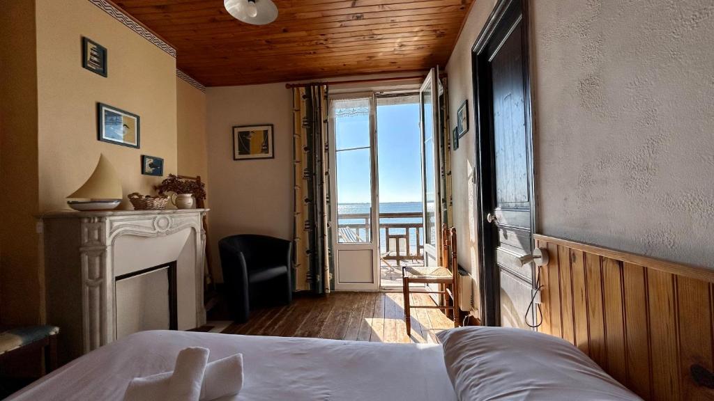 une chambre avec un lit et une vue sur l'océan dans l'établissement La croisière, Séjournez au cœur de la Baie de Somme dans un logement au charme d’antan !, au Crotoy